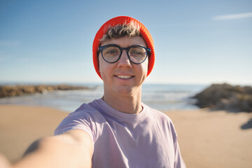Un hombre feliz se toma una selfie en la playa - Un turista masculino disfruta de sus vacaciones de...