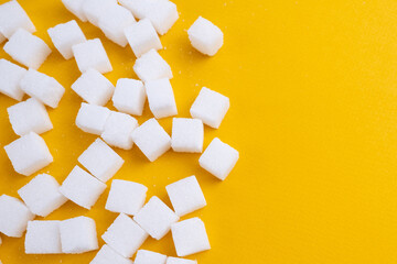 Refined sugar cubes on a colored background. Health and diabetes concept. Sugar kills. Blank space for copy text
