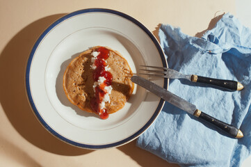 Plant based vegan  strawberry jam and coconut paste whole wheat pancakes top view sunny shot