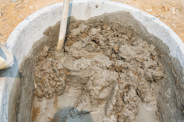 Mix cement sand and stones with hoe leak inside big bucket on floor background - 720101557