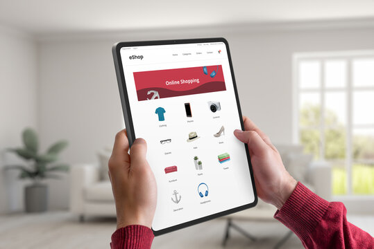 Hands hold a tablet displaying an e-commerce webpage with product categories. Concept of convenient online shopping from home, offering a seamless and modern shopping experience