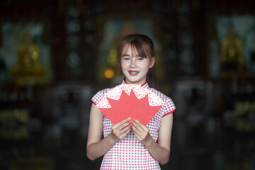 A young Asian girl holding a red envelope of Ang Pao for Chinese New Year