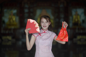 A young Asian girl holding a red envelope of Ang Pao for Chinese New Year