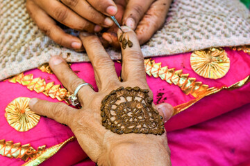 Indian wedding, bride hand applying mehndi, India, Model Release # 773A