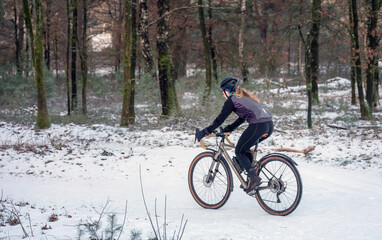 girl on moutain bike in snow covered forest