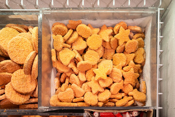 Fish nuggets in the freezer. Frozen food counter at the supermarket.