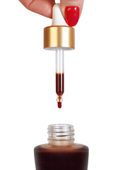A drop of face self-tanning concentrate from a pipette drips into a bottle