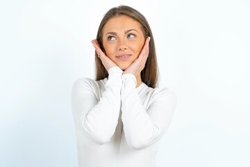 Fototapeta premium Inspired young beautiful caucasian woman wearing white long sleeve T-Shirt looking at copyspace having thoughts about future events