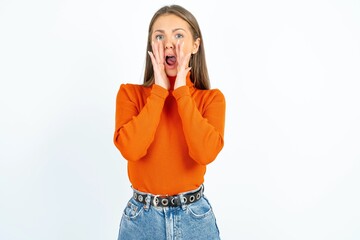 young beautiful caucasian woman wearing orange turtleneck shouting excited to front.