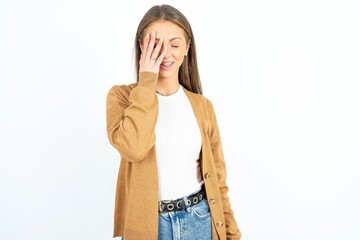 beautiful girl wearing casual clothes makes face palm and smiles broadly, giggles positively hears...
