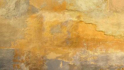Old wall background with peeled and washed out colors in different shades and cracks of yellow and gold.