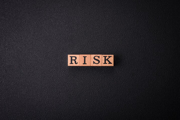The inscription Risk made of wooden cubes on a plain background