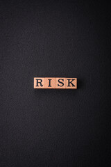 The inscription Risk made of wooden cubes on a plain background
