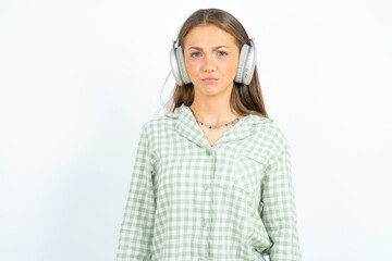 Displeased young beautiful woman wearing green plaid pyjama,  frowns face feels unhappy has some...