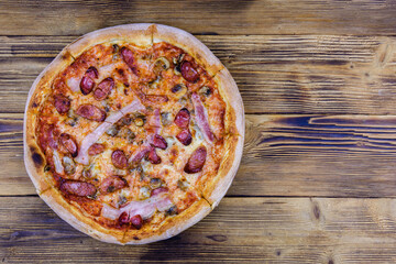 Pizza with salami sausage and parmesan cheese on a wooden table. Top view