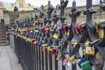View of Vltava river and Prague castle through the fence with love locks. 