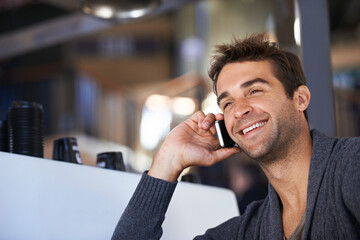 Phone call, happy and young man networking for deal, good news or work communication in cafe. Smile, satisfaction and male person on mobile conversation with cellphone for career in coffee shop.