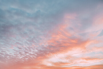 A beautiful sky tinted by the sun leaving vibrant shades of gold, pink, blue and multicolored. Clouds in the twilight evening and morning sky. Cloudy sky background in the evening and during the day.