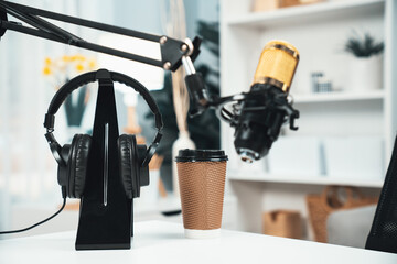 All stuff sets of live streaming standing on white desk consist of microphone, headsets, coffee cup, smartphone, glasses and notebook. Concept of equipment for coaching host channel. Tastemaker. - obrazy, fototapety, plakaty