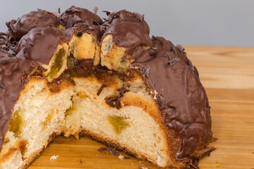 Partly cut chocolate panettone with profiteroles, fragment close-up