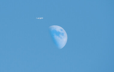 un avion avec La lune en fond de ciel bleu