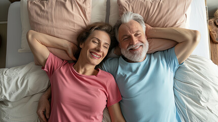 Beautiful and happy mature couple, Joyful man and woman, lying in bed, sharing smiles and happiness