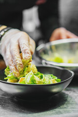 Chef cooking Caesar salad on restaurant kitchen