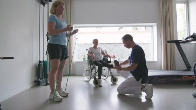 elderly and adult women engaging in physical rehabilitation exercises at a physiotherapy center