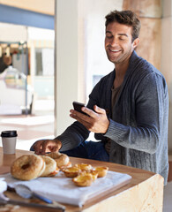Phone, smile and man with breakfast at restaurant networking on social media, mobile app or...