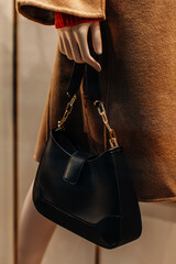 Classic black leather women's handbag with gold chain. Fashion details