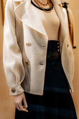 Fancy details of a classic white jacket with golden buttons and black skirt. Women's fashion clothing and accessories
