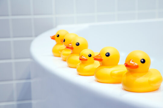 yellow rubber duck on top of a white bathtub