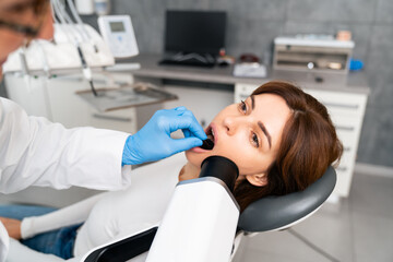 The dentist is examining the patient's teeth.