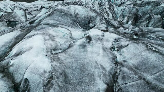 Awe rough glacier surface, white and gray texture of a powerful natural ice formation, close up aerial view. Dynamic and abstract background concept.