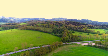 Fototapeta na wymiar Stunning aerial shot over lush green fields and meadows in the countryside.