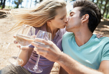 Couple, kiss and wine in nature or forest for celebration of love, holiday and valentines day. Man...