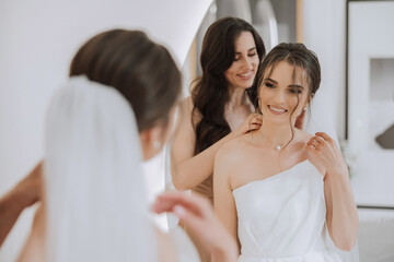 A beautiful bride and her bridesmaids are having fun in the morning. Wedding celebration. Happy girls at their best friend's wedding. A beautiful and elegant bride with her bridesmaids