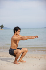 Fototapeta na wymiar Active Lifestyle: Muscular Asian Man Running on the Beach at Sunset