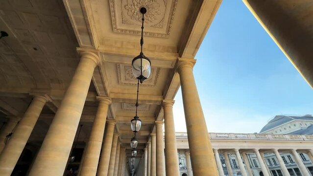Paris, France, Palace Royal "Domaine National du Palais Royal". Sunny summer day. Camera moves forward. Architecture, lamps and columns, famous place Pale Royal Garden