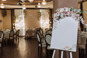 An original floral decorated board with a white sheet, against the backdrop of a deserted wedding...