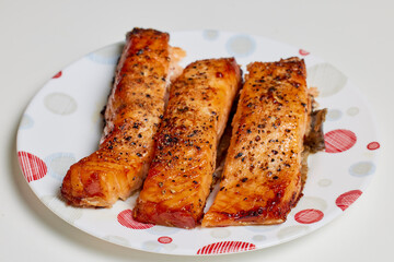 salmon prepared in the oven on a plate ready to be eaten.