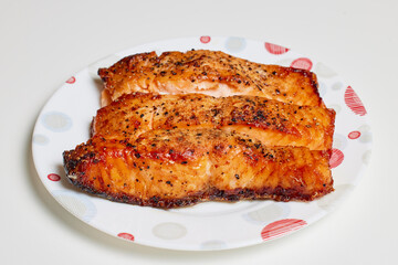 salmon prepared in the oven on a plate ready to be eaten.