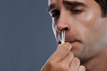 Man, nose and hair with tweezers for cleaning on grey background for self care, wellness or...