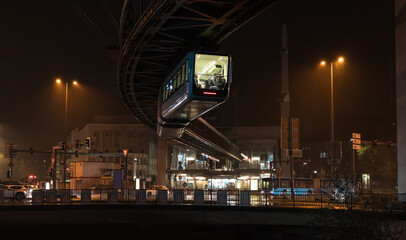 Night cityscape of Wuppertal, North Rhine-Westphalia, Germany: Schwebebahn cable car (electric...