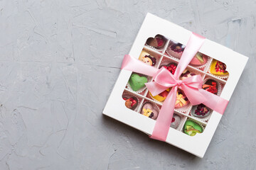 Box with sweet chocolate candies on color background, Various candy sweets. Valentines day gift box. Top view flat lay with copy space