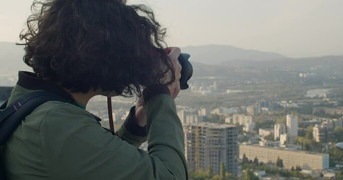 Girl taking pictures of city landscape
