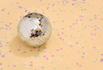 Mirrored glowing disco ball and confetti. Copy space for text.
