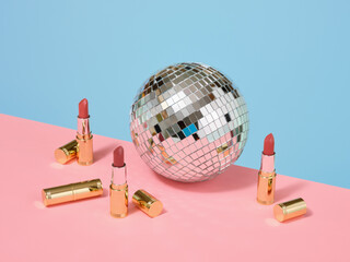 Mirror disco ball and lipsticks. Stylish makeup and party.