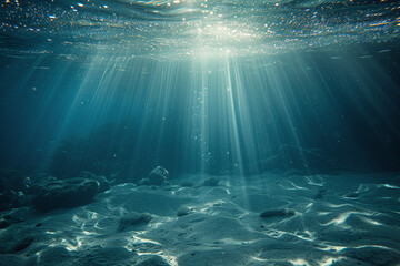 Naklejka premium Underwater Sunlight Cascade, Sparkling Water Particles Above Sandy Ocean Bottom