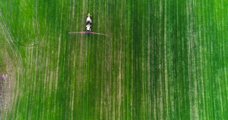 Farming. Top View of Agricultural tractor spraying field.